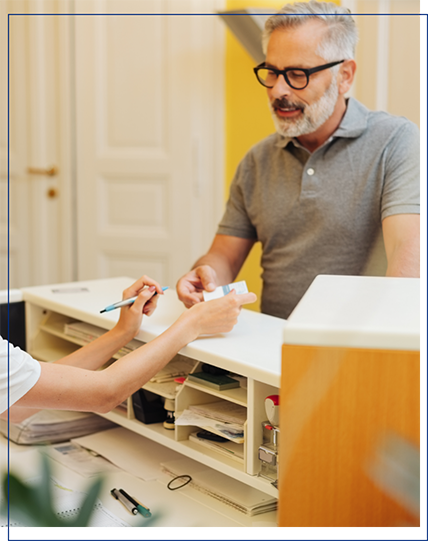 a patient and front desk member smiling
