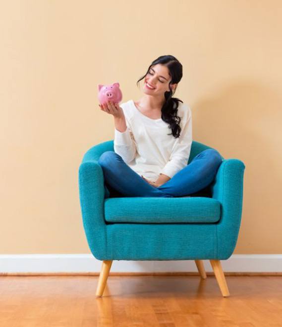 Person dropping a coin into a coin jar