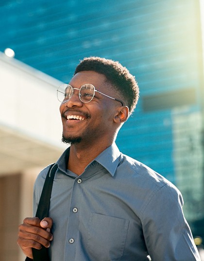 a smiling man walking in a city