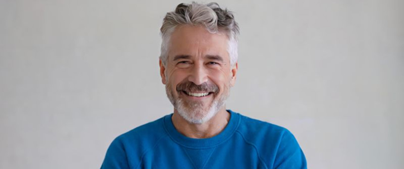 Confident, smiling senior man in blue sweater