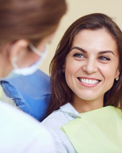a patient smiling while visiting her holistic dentist