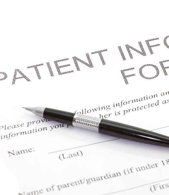 new patient forms with a pen sitting on top of them