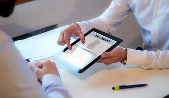 a patient filling out their dental insurance information on a tablet