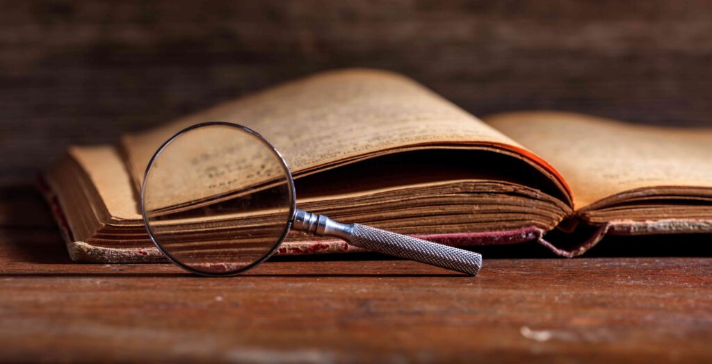 Old book and a magnifying glass