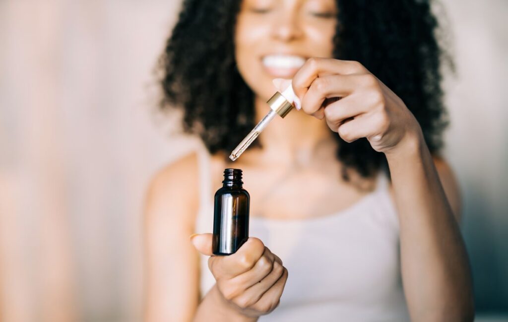A woman holding a bottle of essential oil